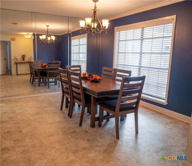 dining area with a textured ceiling, a notable chandelier, and ornamental molding