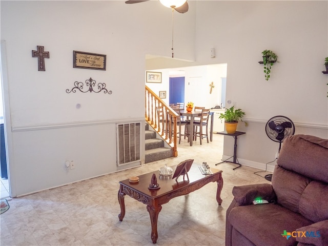 living room featuring a high ceiling and ceiling fan