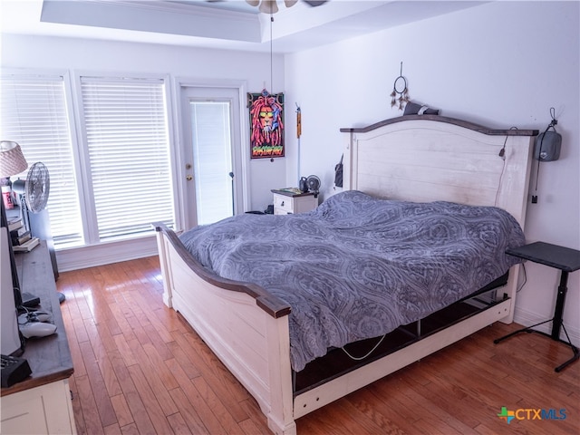 bedroom featuring wood-type flooring, multiple windows, and ceiling fan