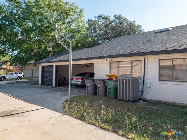 view of side of home with a garage and central AC