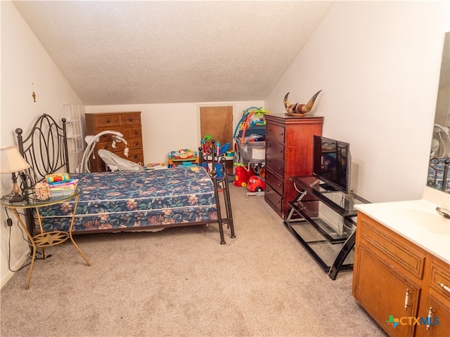 carpeted bedroom with sink and a textured ceiling