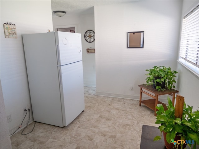 kitchen with a textured ceiling and white fridge