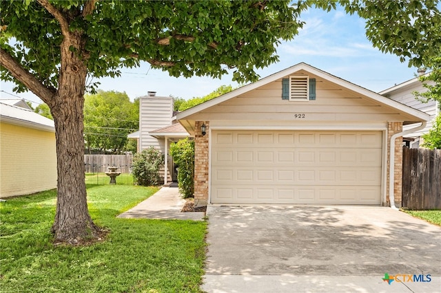 view of front of home featuring concrete driveway, brick siding, fence, and a front yard