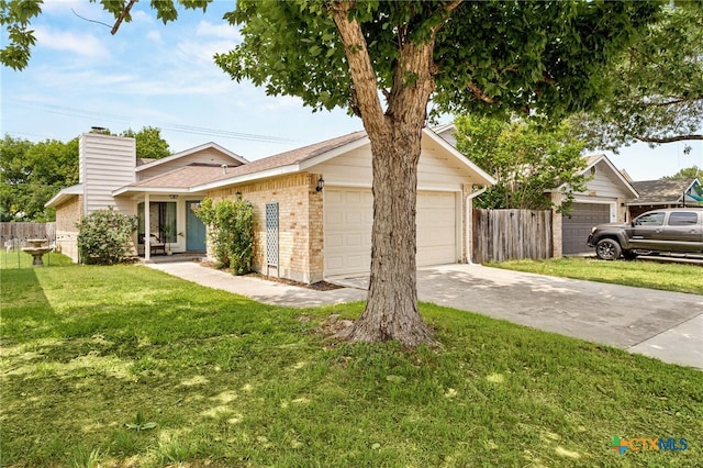 view of front of property featuring a garage, brick siding, fence, and a front yard