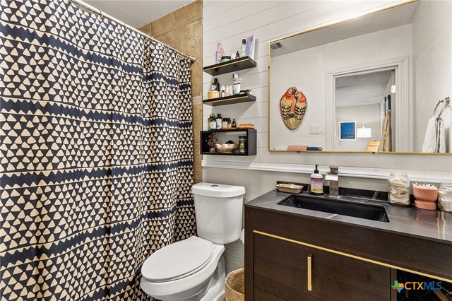 bathroom featuring vanity, toilet, a shower with curtain, and visible vents
