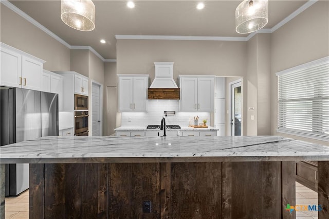 813 Reston Rd, Temple, TX 76502 - kitchen with stainless steel appliances, premium range hood, a spacious island, decorative backsplash, and white cabinets