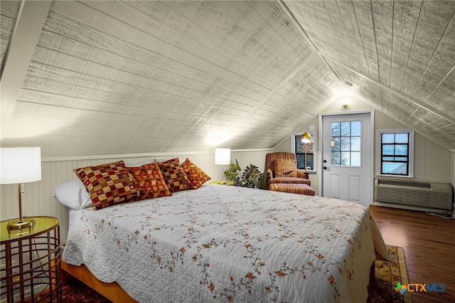 bedroom featuring dark wood-type flooring, an AC wall unit, and vaulted ceiling