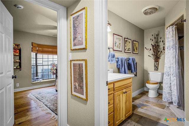 bathroom with vanity, wood-type flooring, and toilet