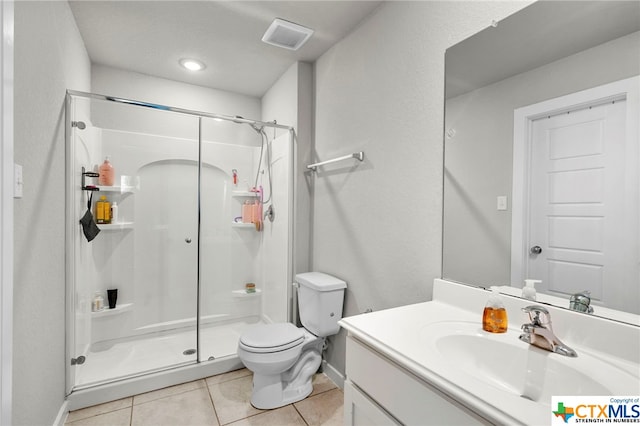 bathroom featuring vanity, tile patterned floors, toilet, and an enclosed shower