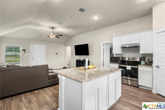 kitchen with light hardwood / wood-style floors, vaulted ceiling, a kitchen island, white cabinetry, and appliances with stainless steel finishes