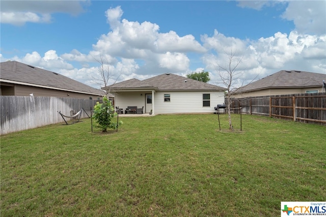 back of house with a patio area and a yard