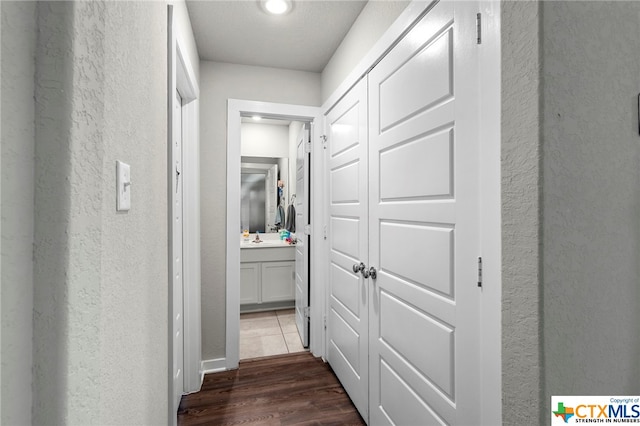 hallway featuring dark wood-type flooring and sink