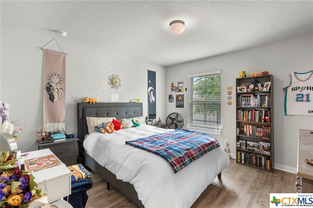 bedroom featuring wood-type flooring and a textured ceiling