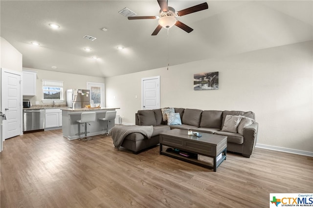 living room featuring light hardwood / wood-style floors, ceiling fan, and lofted ceiling