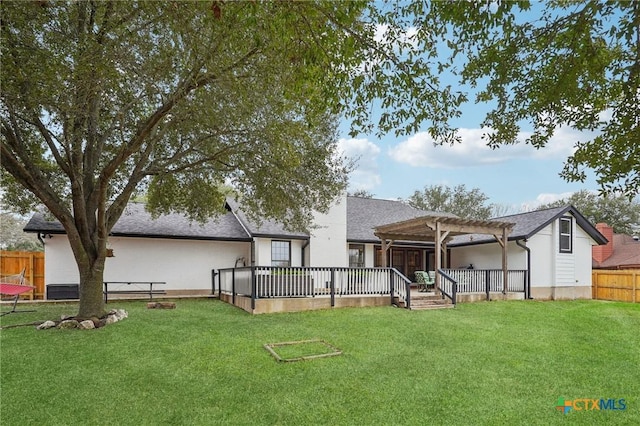 rear view of property featuring a wooden deck, a yard, and a pergola