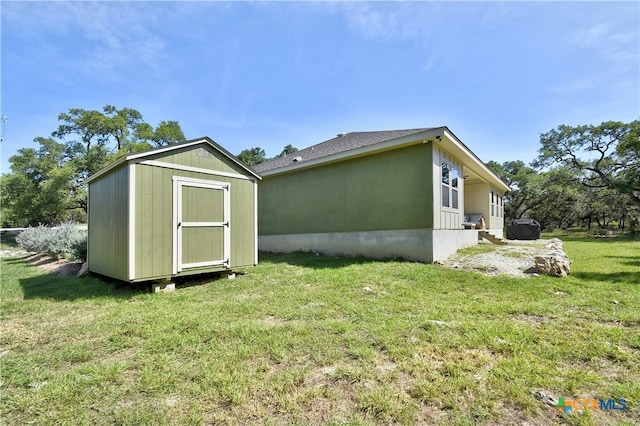 exterior space featuring a lawn and a storage unit