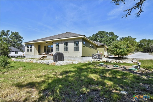 rear view of house featuring a yard