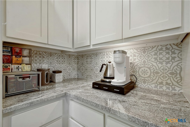 kitchen featuring white cabinetry and light stone countertops