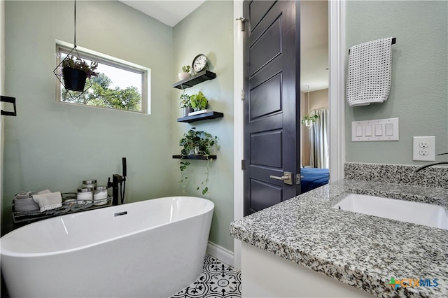 bathroom featuring a bathtub, vanity, and tile patterned floors