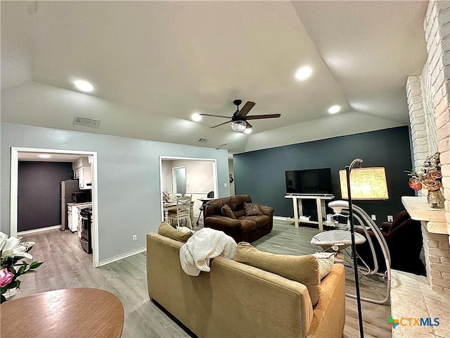 209 Roanoke Dr, Victoria, TX 77904 - living area featuring vaulted ceiling, ceiling fan, light wood finished floors, and a brick fireplace