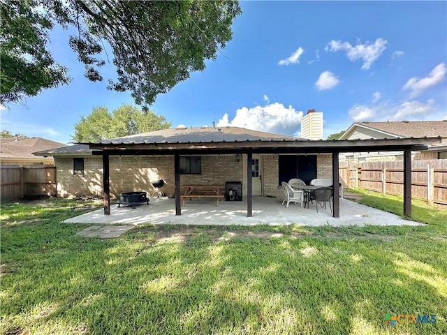 209 Roanoke Dr, Victoria, TX 77904 - back of house featuring brick siding, a patio area, a fenced backyard, and a chimney