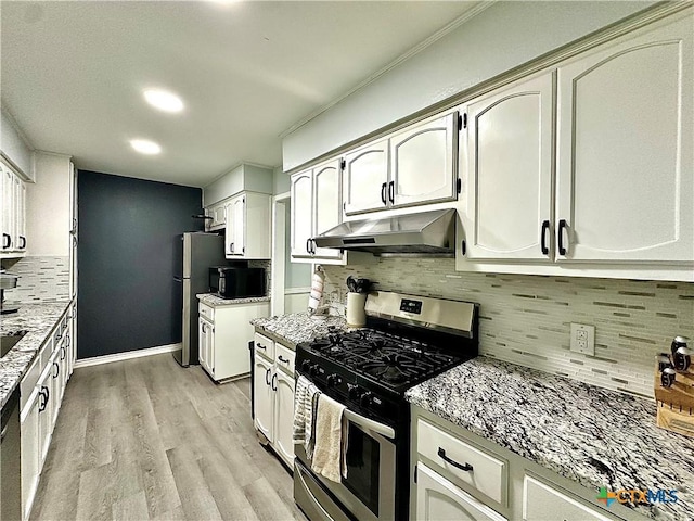 209 Roanoke Dr, Victoria, TX 77904 - kitchen featuring stainless steel appliances, under cabinet range hood, light wood-type flooring, decorative backsplash, and light stone countertops