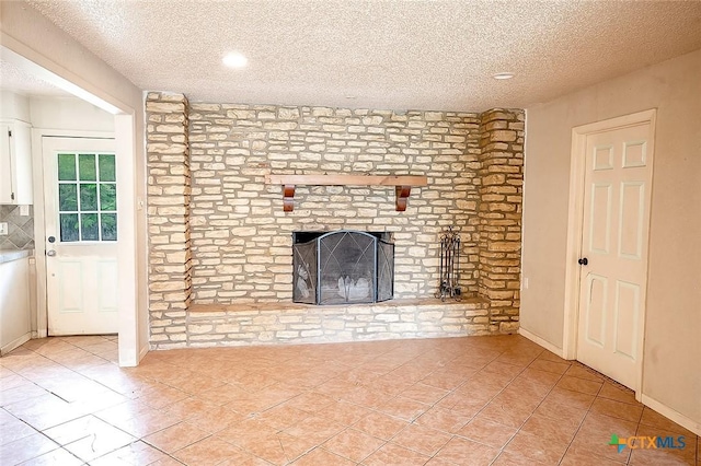 117 N 28th St, Gatesville, TX 76528 - unfurnished living room featuring a textured ceiling, light tile patterned floors, a fireplace, and recessed lighting