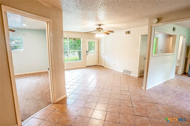 117 N 28th St, Gatesville, TX 76528 - spare room with a textured ceiling, ceiling fan, light carpet, light tile patterned floors, and baseboards