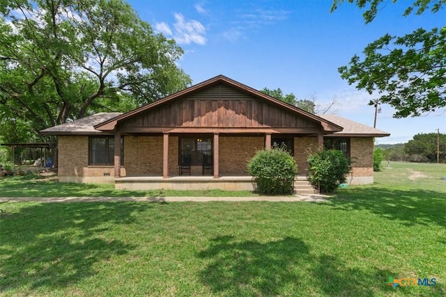 back of property with brick siding and a lawn
