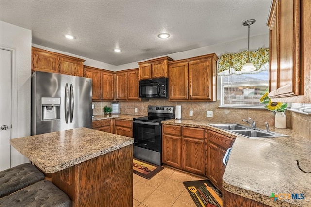 709 Aries Ave, Killeen, TX 76542 - kitchen with appliances with stainless steel finishes, a sink, a breakfast bar area, backsplash, and a textured ceiling