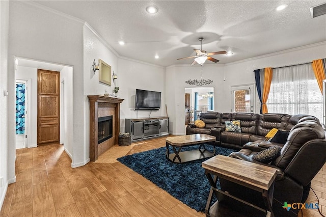 709 Aries Ave, Killeen, TX 76542 - living area with a ceiling fan, ornamental molding, a glass covered fireplace, a textured ceiling, and light wood finished floors