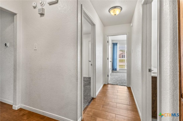 709 Aries Ave, Killeen, TX 76542 - corridor with wood finished floors, baseboards, and a textured wall