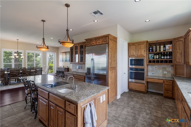 1280 Mystic Pkwy, Spring Branch, TX 78070 - kitchen featuring built in appliances, an island with sink, backsplash, recessed lighting, and glass insert cabinets