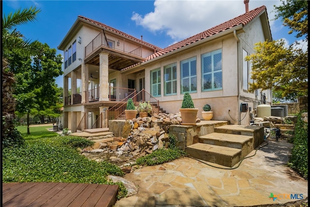 1280 Mystic Pkwy, Spring Branch, TX 78070 - back of house with stairs, stucco siding, a balcony, a tiled roof, and a patio area