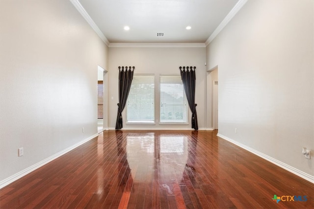 spare room featuring dark wood-type flooring and crown molding