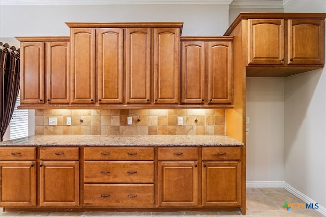 kitchen featuring light tile patterned floors, light stone counters, and tasteful backsplash