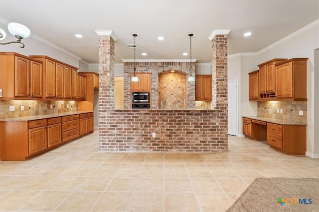 5909 Turtle Creek Trl, Temple, TX 76502 - kitchen with decorative columns, stainless steel microwave, light tile patterned floors, decorative backsplash, and brown cabinets