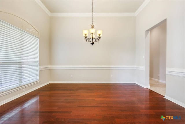 spare room with ornamental molding, a chandelier, and dark hardwood / wood-style floors