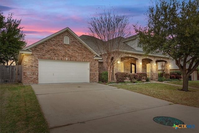 view of front of property featuring a garage and a yard