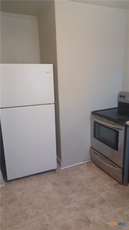 kitchen with electric range, light floors, and freestanding refrigerator