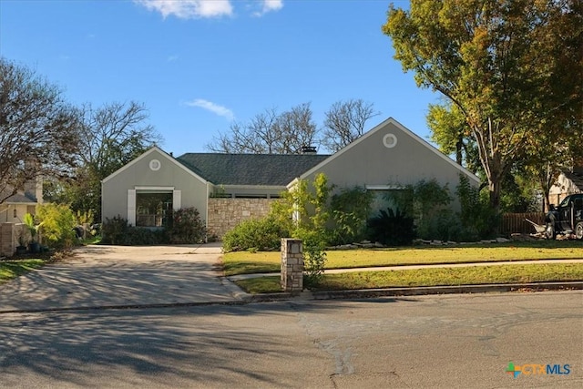 single story home featuring fence, a front lawn, concrete driveway, and stucco siding