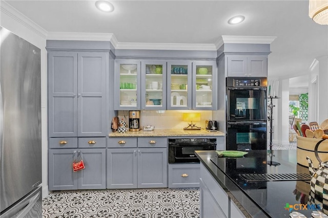 6115 Country Club Dr, Victoria, TX 77904 - kitchen with freestanding refrigerator, gray cabinets, stone counters, glass insert cabinets, and ornamental molding