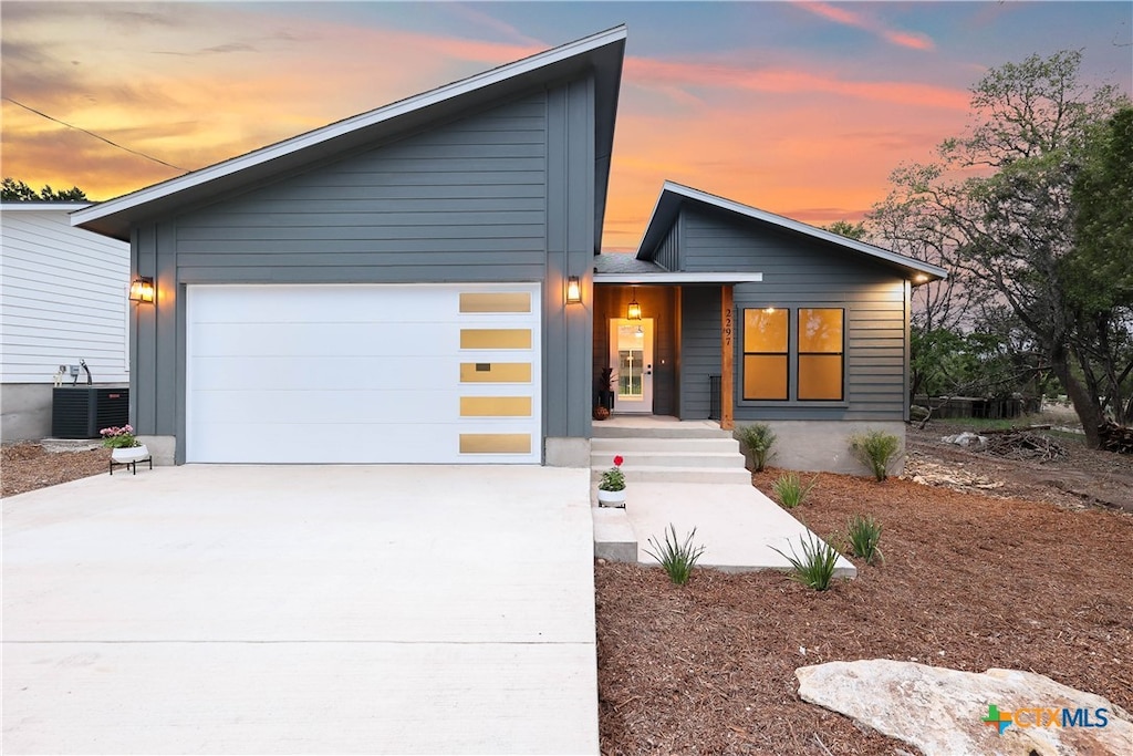 view of front facade featuring a garage and central AC