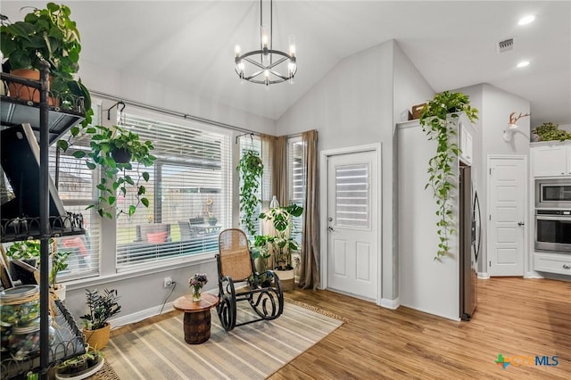 foyer featuring visible vents, light wood-style flooring, vaulted ceiling, a chandelier, and recessed lighting