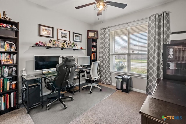 home office with carpet floors, baseboards, and a ceiling fan