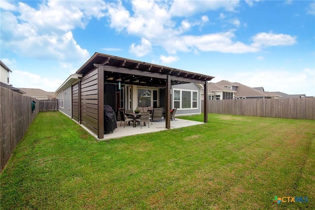 rear view of house featuring a yard, a fenced backyard, and a patio