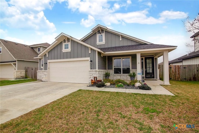 craftsman-style house featuring board and batten siding, a front yard, fence, a garage, and driveway