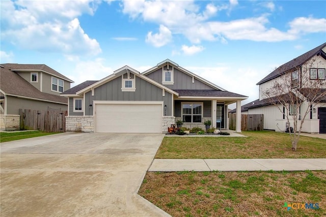 craftsman house with covered porch, fence, a front lawn, and board and batten siding