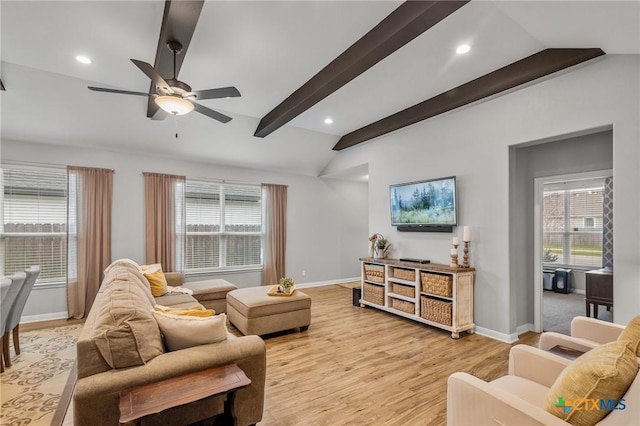 living room with vaulted ceiling with beams, light wood finished floors, baseboards, and a healthy amount of sunlight