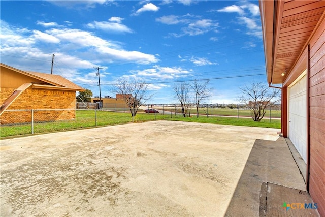 view of patio with concrete driveway, a garage, and fence